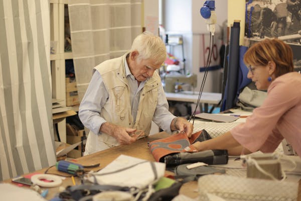 Experienced craftsman repairing leather bag in workshop